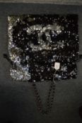 A Chanel large black and silver sequinned bag with chain straps.