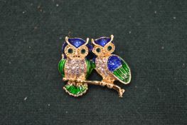 An enamel and diamante owl brooch.