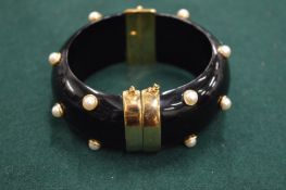 A decorative bangle with pearls.
