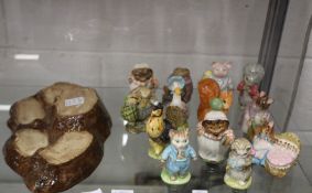 A collection of Beswick Beatrix Potter figures complete with tree stump stand.