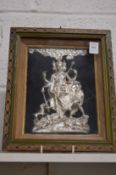 An Eastern impressed metal plaque, possibly silver, depicting figures beneath a tree, framed and