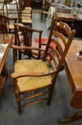 A set of eight oak and rush seated ladder back dining chairs, two with arms.