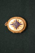 A Victorian yellow metal locket with enamel and seed pearl decoration.