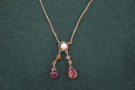 A gold chain set with pearl and pink gem stones.