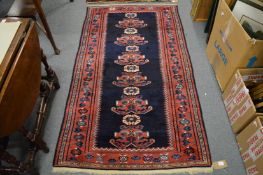 A small Persian design rug, dark blue ground with stylised decoration, 175cm x 100cm.