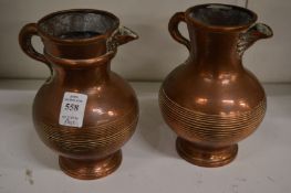 A pair of unusual copper jugs.
