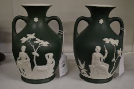 A pair of green Jasperware style twin handled vases with classical decoration.