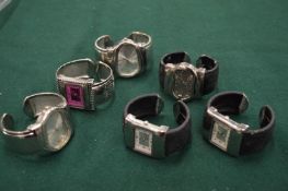 A group of cuff style bracelet watches.