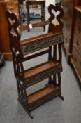 An Art Nouveau oak small three tier bookcase with applied embossed metal panels.