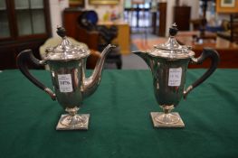 A small silver coffee pot with matching hot water jug.