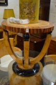 An Art Deco style coffee table, circular top on curving legs.