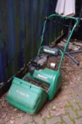 A Qualcast petrol cylinder lawn mower.