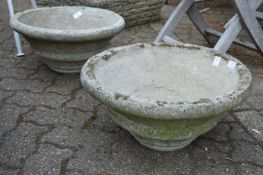 A pair of reconstituted stone circular planters.