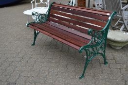 A new garden bench with green painted cast metal ends and hardwood slats.