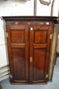 A George III oak hanging corner cupboard.