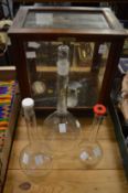 Scientific scales, in a mahogany case together with three scientific glass bottles.