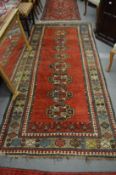 A good Persian design long carpet, red ground with stylised decoration, 275cm x 130cm.
