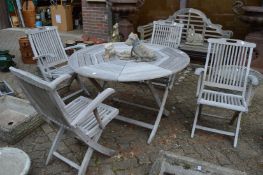 A circular hardwood folding garden table with a set of four folding armchairs.