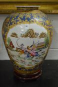 A large Chinese pottery vase decorated with hunting scenes on a hardwood stand.