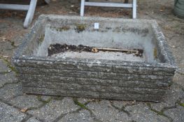 A pair of reconstituted stone rectangular plant troughs.