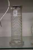 A cut glass vase with silver rim.