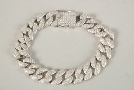 A HEAVY SILVER CZ SET CURB BRACELET.