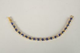 A SILVER GOLD PLATED SAPPHIRE LINE BRACELET.