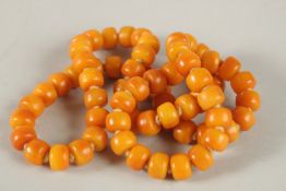 A STRING OF AMBER BEADS. 70cms long.