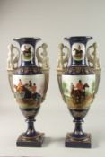 A PAIR OF TWO HANDLED PORCELAIN VASES painted with hunting scenes. 48cms high.