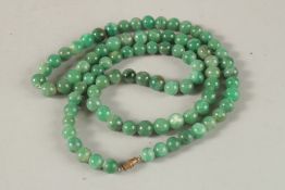 A GREEN JADE NECKLACE. 80cms long.