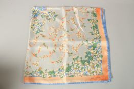 A PIERRE BALMAIN, PARIS, ORANGE AND BLUE FLOWERS SILK SCARF. 90cms x 86cms.