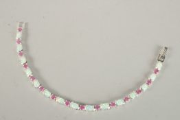 A SILVER, RUBY AND OPAL LINE BRACELET.