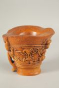 A CARVED HORN LIBATION CUP. 12cms high.