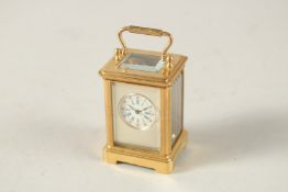 A PLAIN GILT MINI CARRIAGE CLOCK. 6cms high.