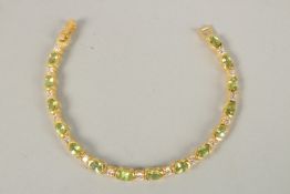 A SILVER GOLD PLATED PERIDOT LINE BRACELET.