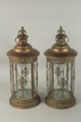 A PAIR OF METAL GLAZED CIRCULAR LANTERNS. 55cms high.