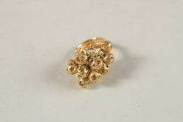 A CARTIER 18CT YELLOW GOLD RING, mounted with a cluster of open spheres. Ring size (M).