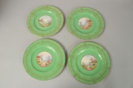 A SET OF FOUR ROYAL WORCESTER CIRCULAR GREEN PLATES the centres painted with a college and flowers