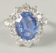 AN 18CT WHITE GOLD OVAL SAPPHIRE AND RBC DIAMOND CLUSTER RING WITH DIAMOND SHOULDERS, boxed.