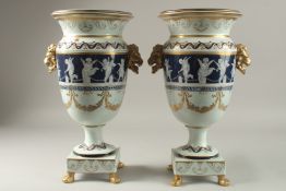 A LARGE PAIR OF SEVRES DESIGN PORCELAIN URN SHPAPED VASES ON STANDS with gilt lion mounts. 43cm