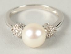 A 9CT WHITE GOLD CULTURED PEARL RING WITH DAISY STYLE DIAMOND CLUSTER SHOULDERS. R/C diamonds 1.