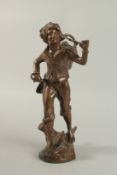A BRONZE OF A YOUNG BOY carrying a basket on a stick. 34cm high.