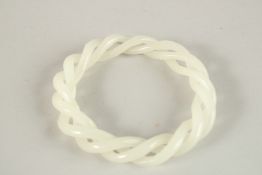 A PIERCED WHITE JADE TWIST BANGLE. 8cms diameter.