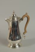 A GEORGIAN STYLE SILVER COFFEE POT with wooden handles. London 1967, weight 22ozs.