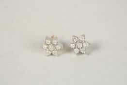 A PAIR OF 9CT GOLD SEVEN STONE DIAMOND DAISY EAR STUDS.