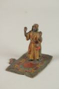 A SMALL COLD PAINTED BRONZE ARAB standing on a rug. Possibly BERGMAN. 8cms x 7cms.