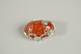 A SILVER AND AMBER BROOCH.