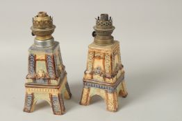 A PAIR OF FRENCH ART POTTERY EIFFEL TOWER LAMPS with paraffin burners. 28cms high.
