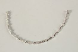 A 14CT WHITE GOLD AND DIAMOND LINE BRACELET. 116grms.