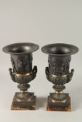 A VERY GOOD PAIR OF CLASSICAL BRONZE TWO HANDLED URNS on Blue John square bases. 37cms high.